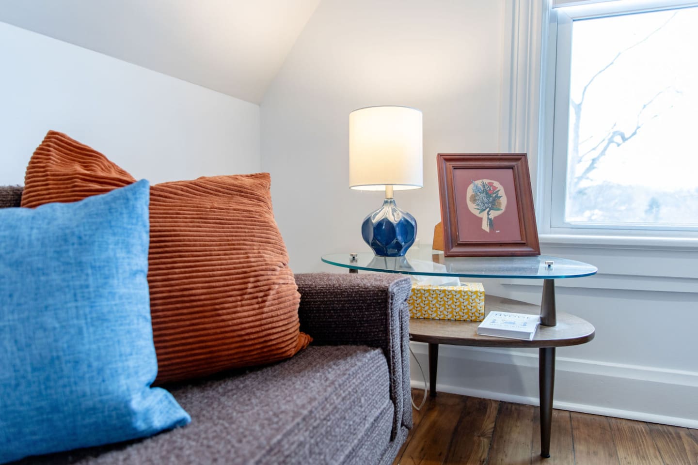 A collection of soft pillows on a cozy bed, paired with a stylish side table holding a warm lamp, creating a peaceful and inviting atmosphere.