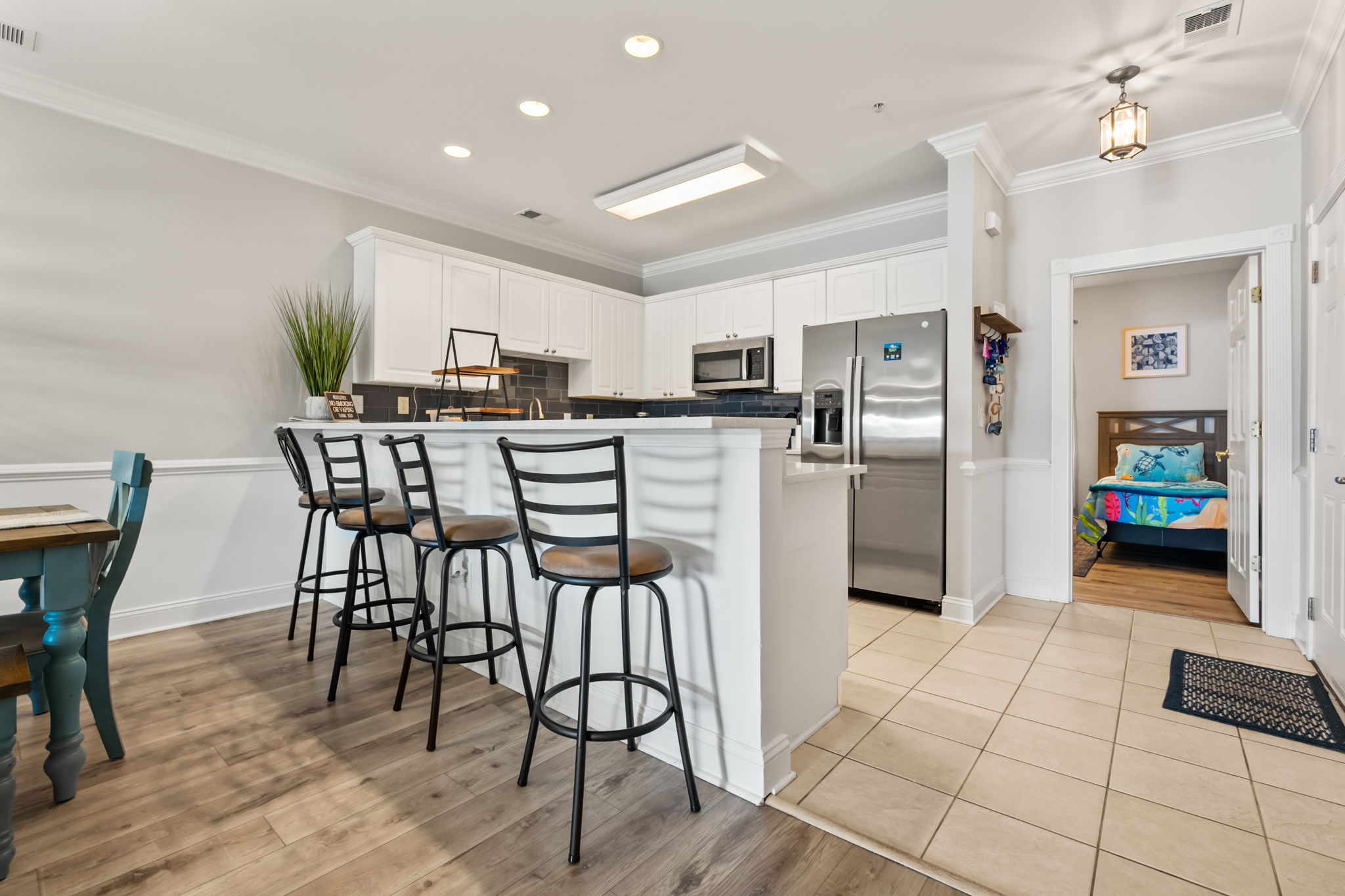 A well-designed kitchen featuring a spacious countertop, modern appliances, and counter stools for casual seating—perfect for cooking, dining, and enjoying a meal in a cozy, functional space