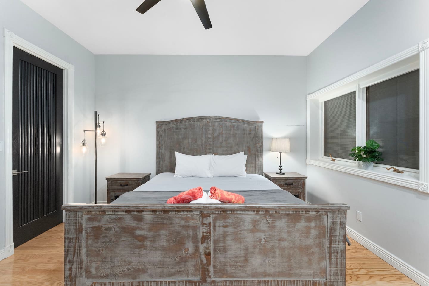 Enjoy a peaceful stay in this serene room with large windows, rustic charm, and modern lighting.