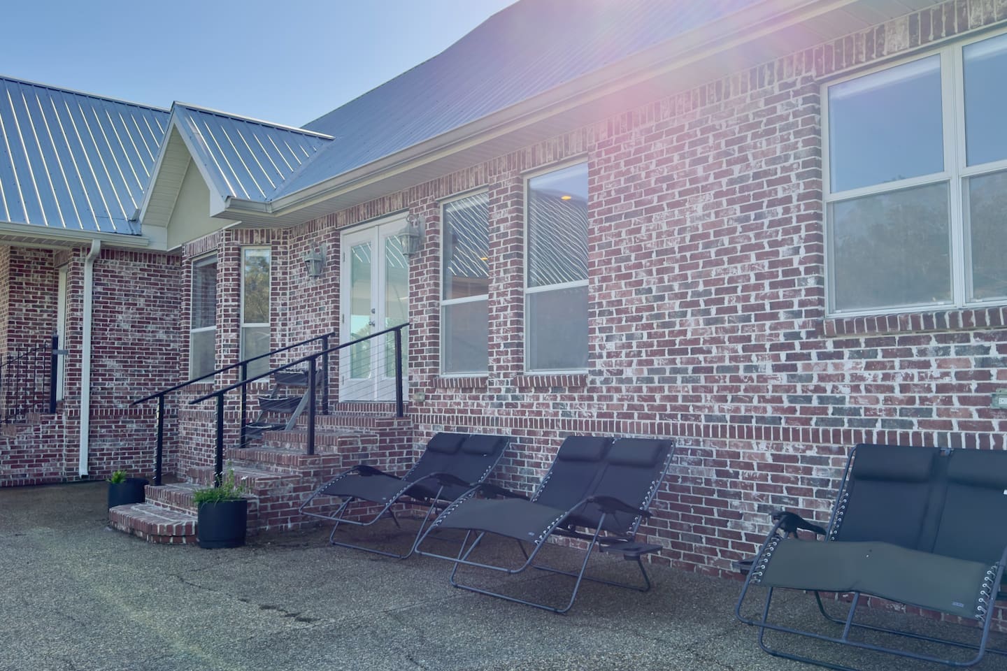 Reclining lounge chairs line the paved patio, offering the perfect spot to soak up the sun.
