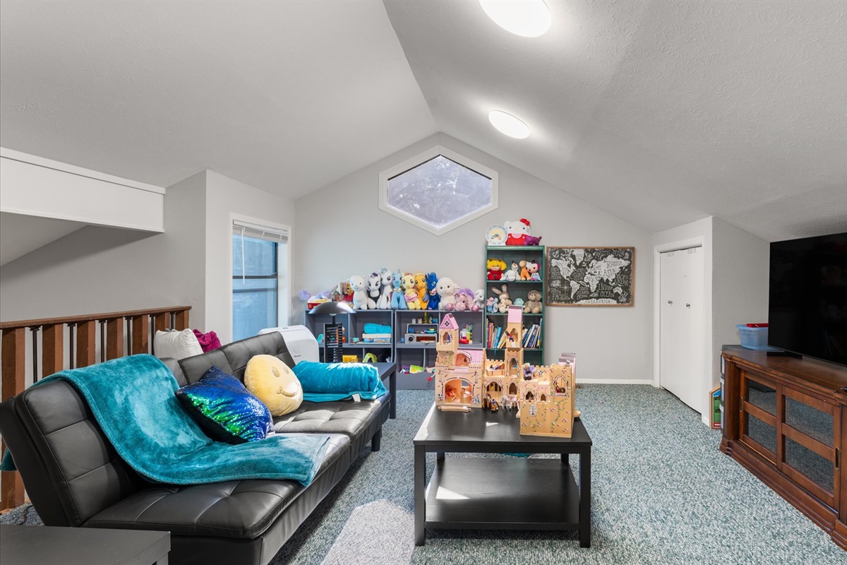 Children’s Loft features a 65" TV, toys for ages 2-8, including Barbies, trucks, books, and games. A fold-out couch can fit a small adult, with fresh linens, blankets, and pillows provided.