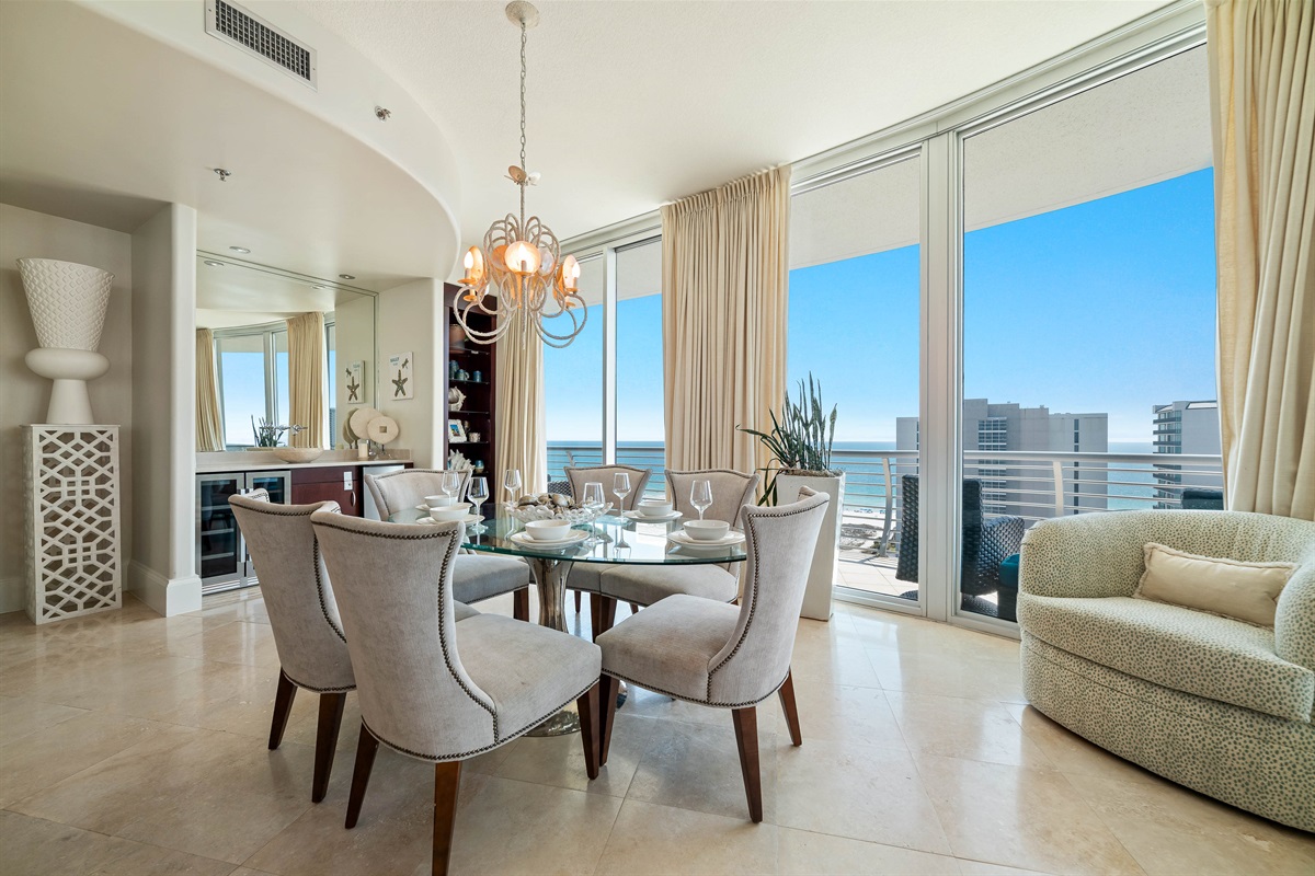 Sophisticated dining with panoramic coastal views. This exquisite 6-seater dining area is the centerpiece for formal entertaining, featuring premium stone flooring, custom cabinetry, and a captivating waterfront backdrop