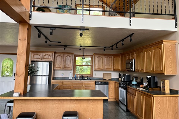Spacious kitchen with coffee bar, basic spices and necessities for cooking and eating.  Four stools align the counter. Opens into living room so never away from the action or view. 