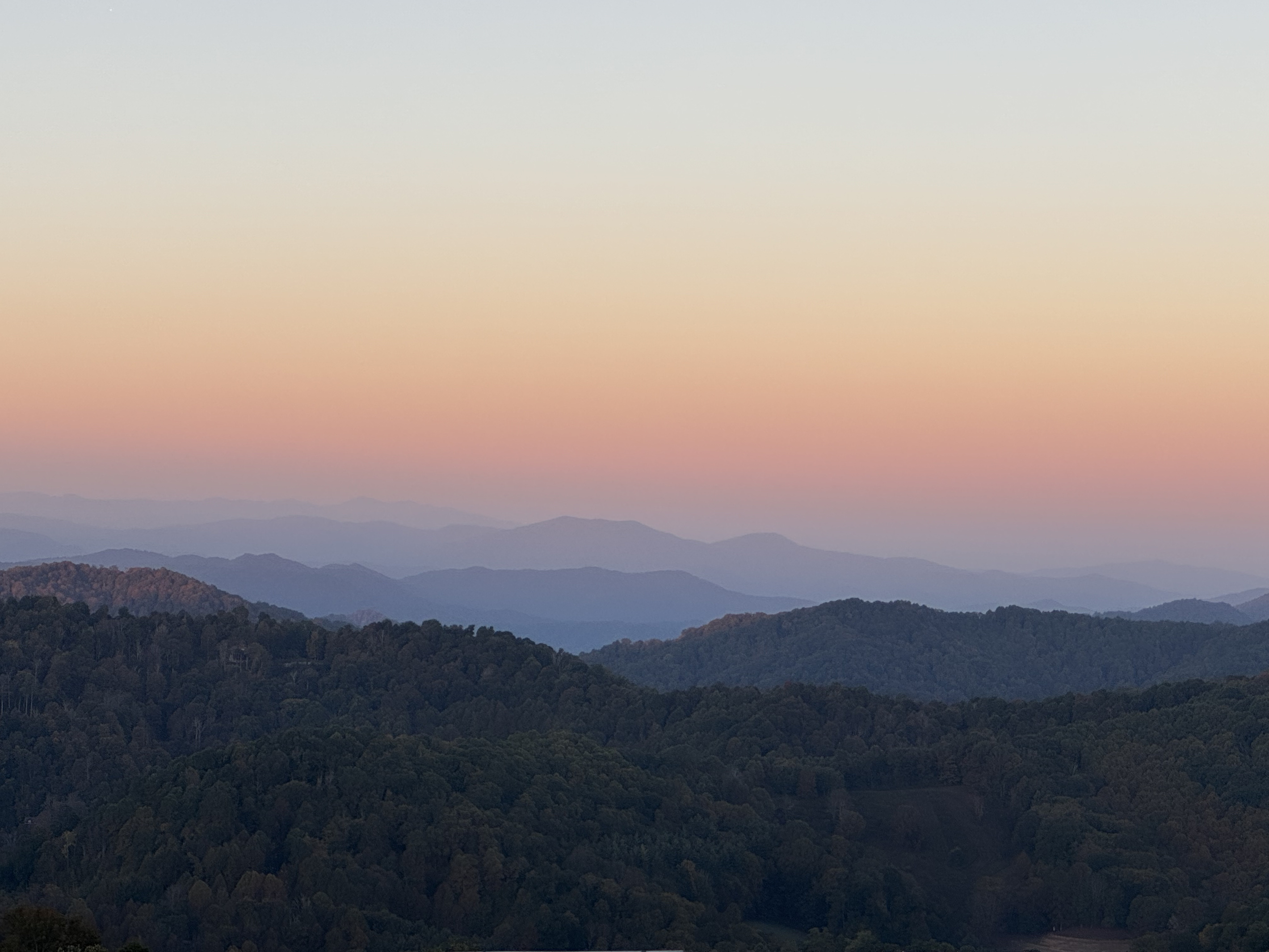 Soft evening colors settle over the layers of Blue Ridge mountain ridges.