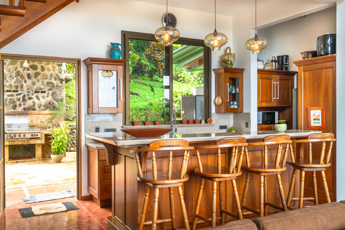 Chef's kitchen with wet bar open to jungle and garden views