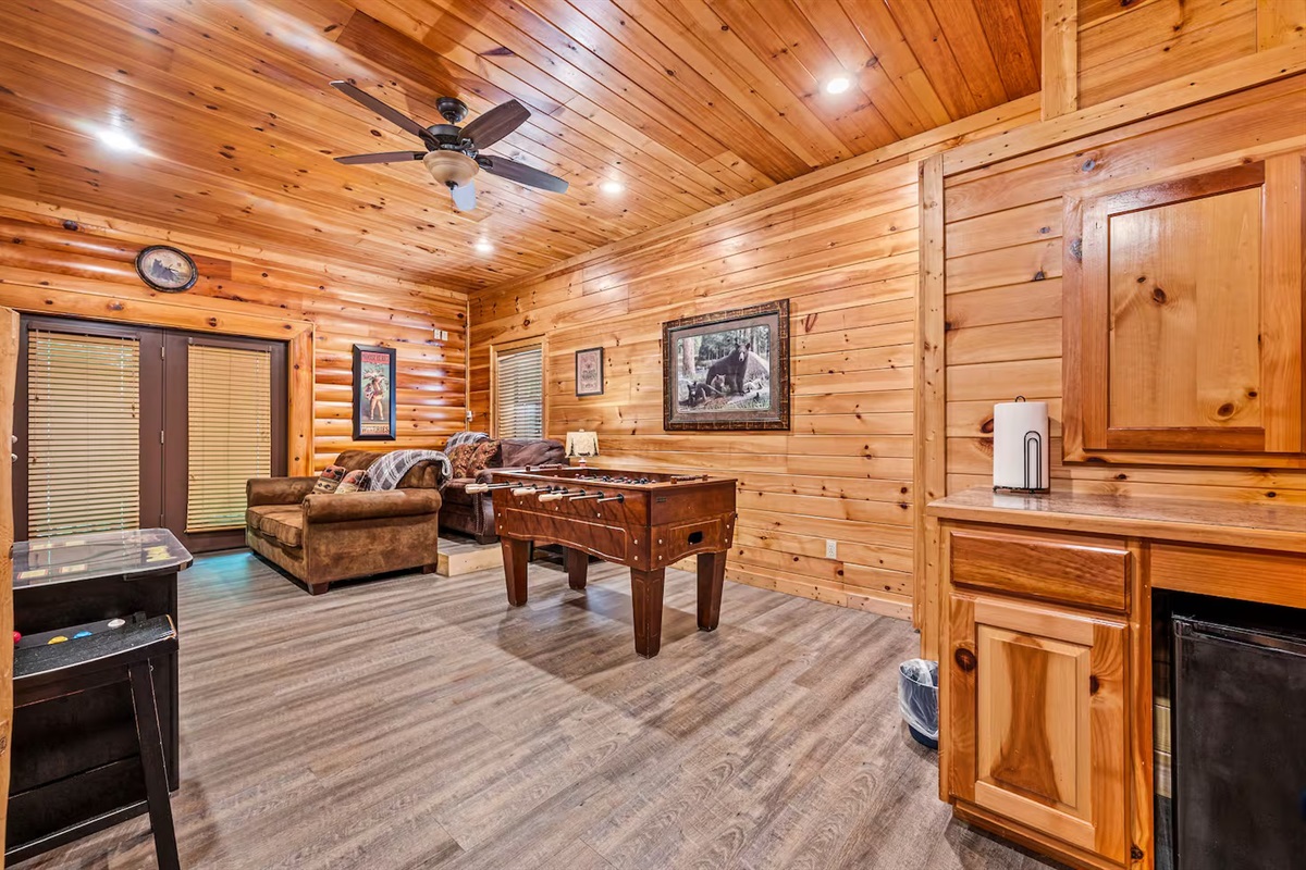 Open concept lower level game room with arcade, Foosball, TV and laundry