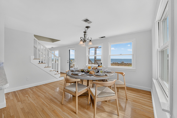 Enjoy meals together in a bright dining space surrounded by windows and coastal scenery.
