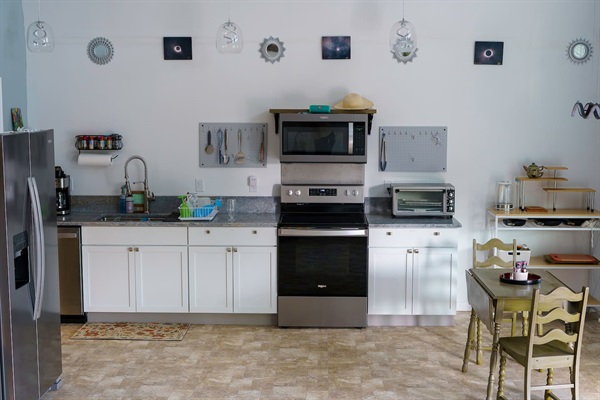 View of kitchen counter & appliances, kitchen cart with toaster, kitchen table. 