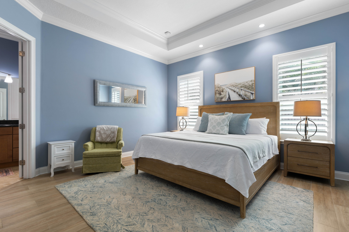 Primary Suite with a king bed, soft blue walls, a reading chair and its own ensuite bath for real rest.