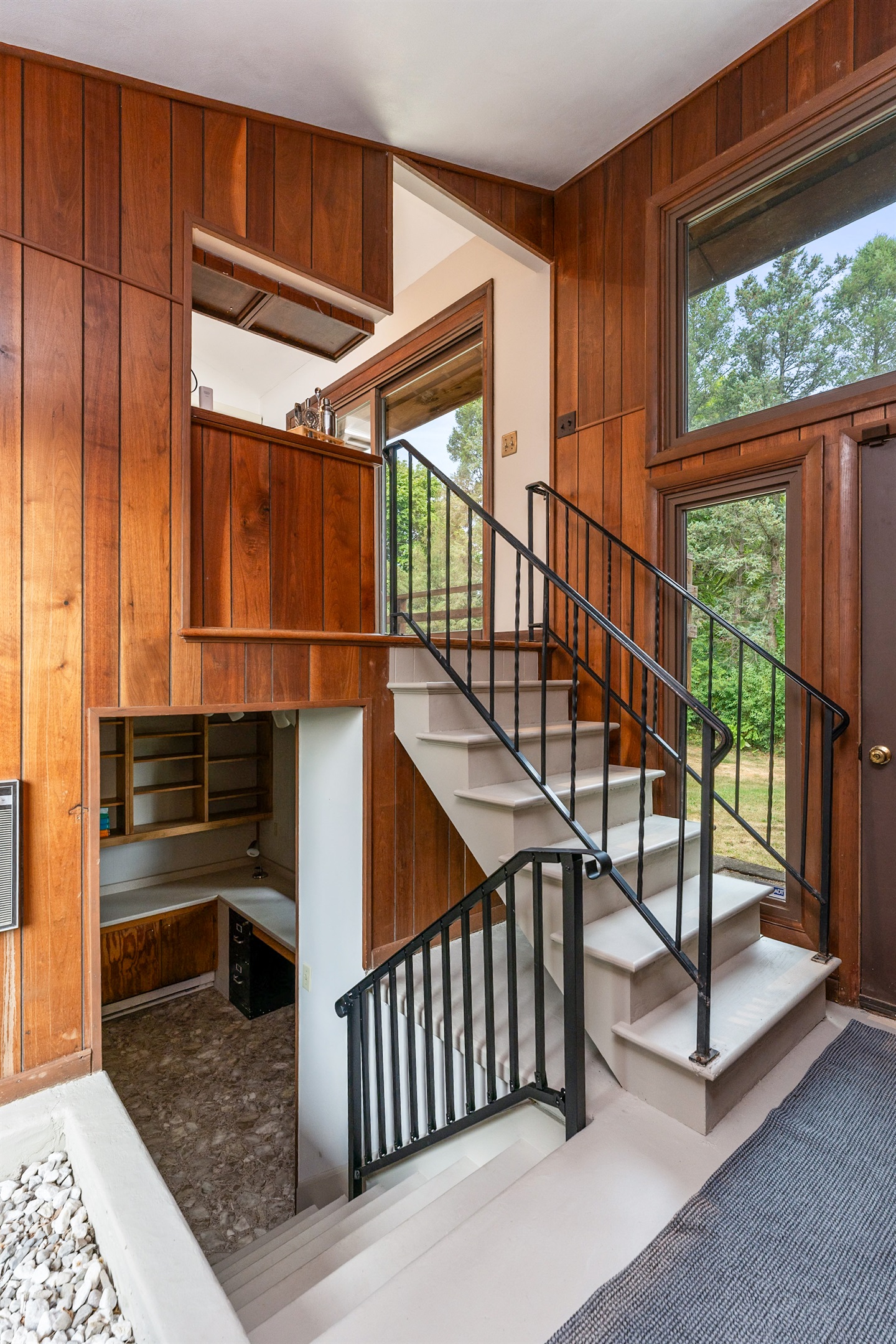 Unique split-level entryway with warm wood paneling, natural light, and open sightlines to multiple levels.