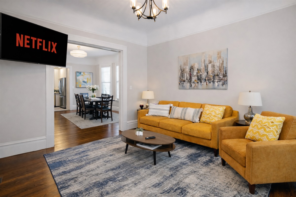 Relax on our sofa in this vibrant, modern living room. Whether you're settling in for a Netflix marathon on the large wall-mounted TV or enjoying a quiet morning with a book, this space is designed for comfort.