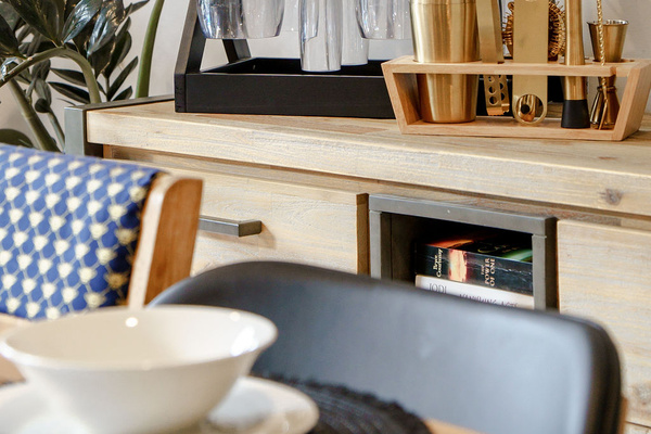 The dining sideboard includes glassware and bar tools, adding a useful entertaining detail beside the open-plan dining area.