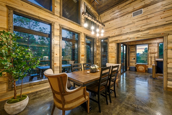 Rustic wood cabin kitchen with island, warm lighting, and forest views