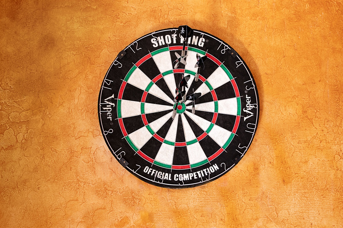 Challenge your aim and enjoy some friendly competition with this classic wall-mounted dartboard set against warm textured walls.