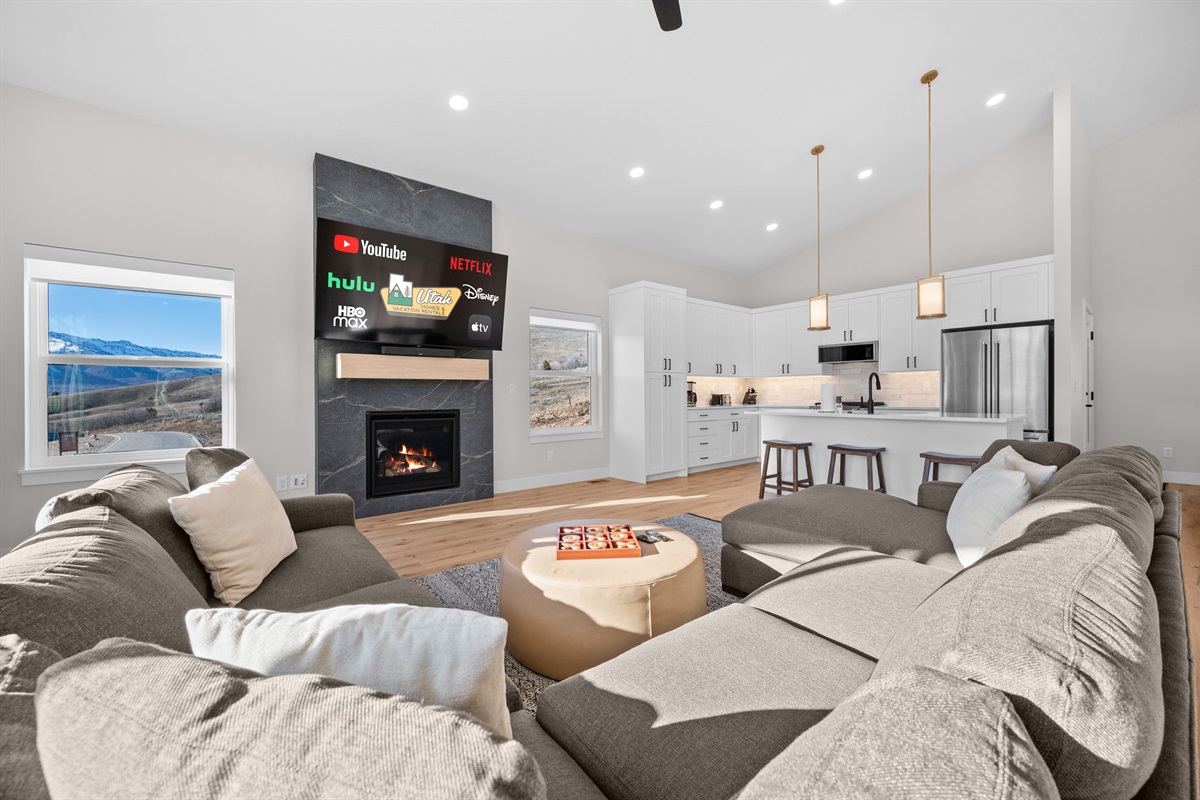 Spacious living area featuring cozy sectional seating, gas fireplace, and seamless flow into the kitchen.