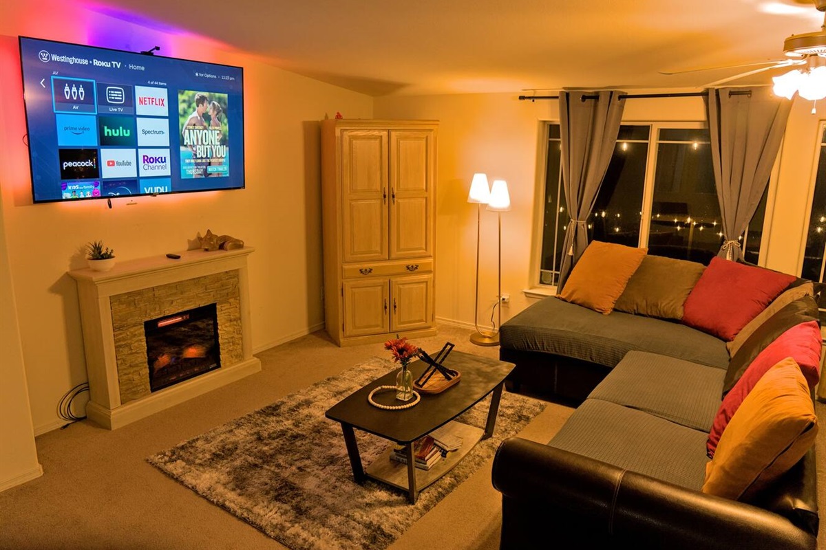 Welcome to a cozy haven where warmth and entertainment seamlessly coalesce. The ambient glow of the electric fireplace sets the mood, complemented by the immersion TV LED Backlight.