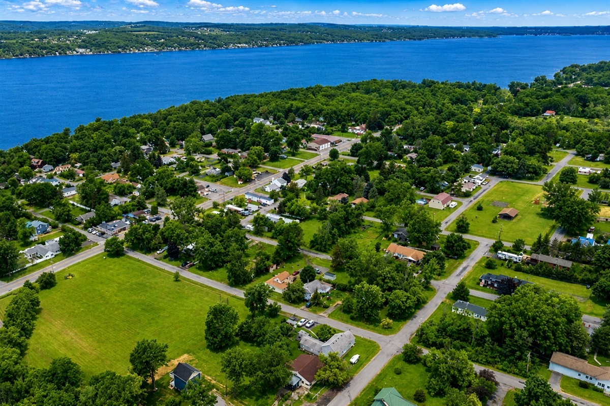A scenic aerial view of lakeside living—this charming community offers lush greenery, walkable streets and breathtaking Canandaigua Lake. Ideal for those seeking serenity with convenience.
