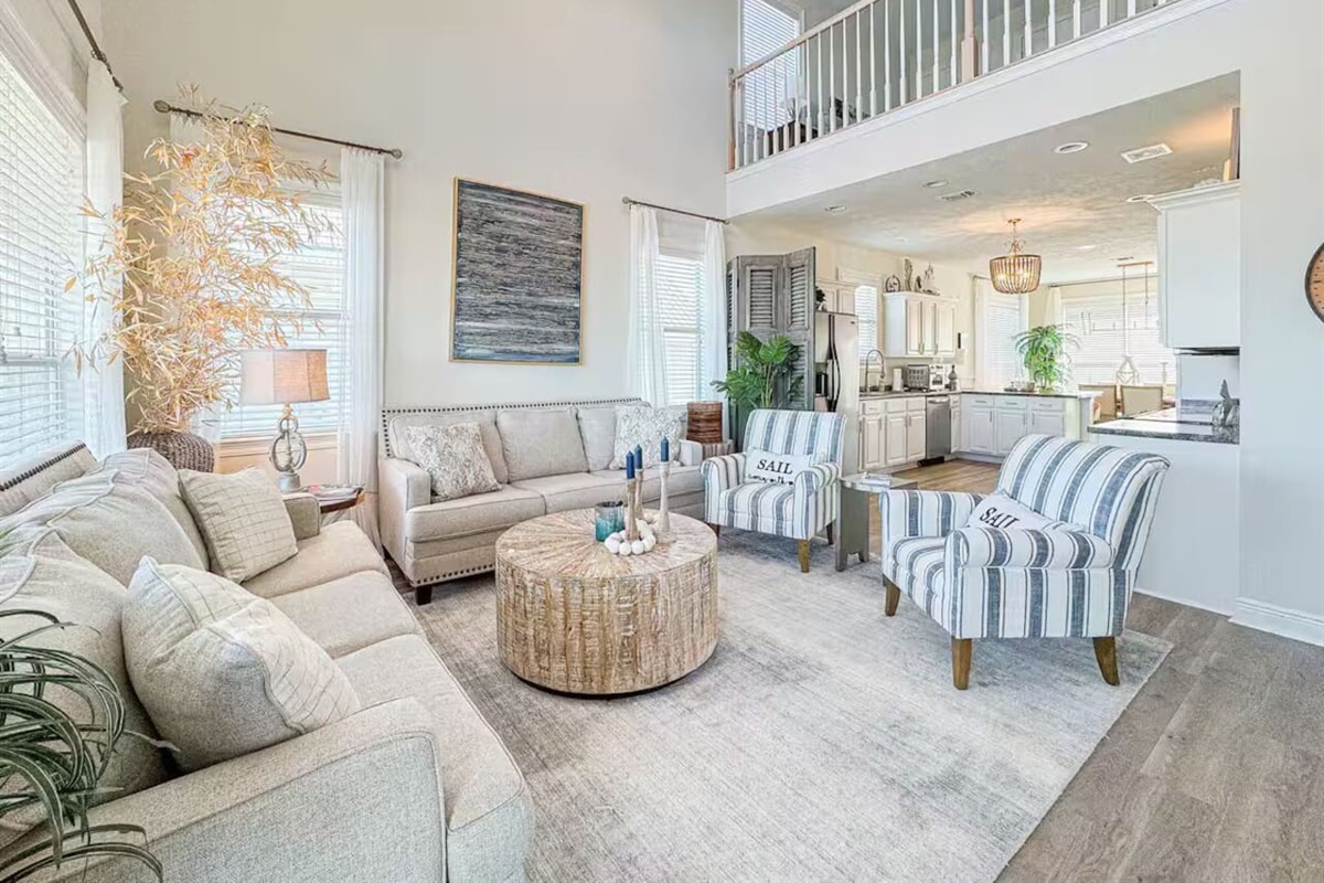 Spacious living room featuring cozy seating, airy ceilings, and an open design ideal for lounging and entertaining.