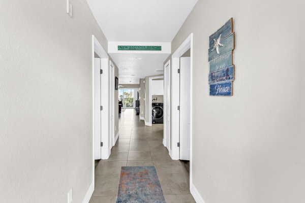 Entrance to 3 condo with bedrooms to left and right, hallway to bathroom, kitchen and living area. 