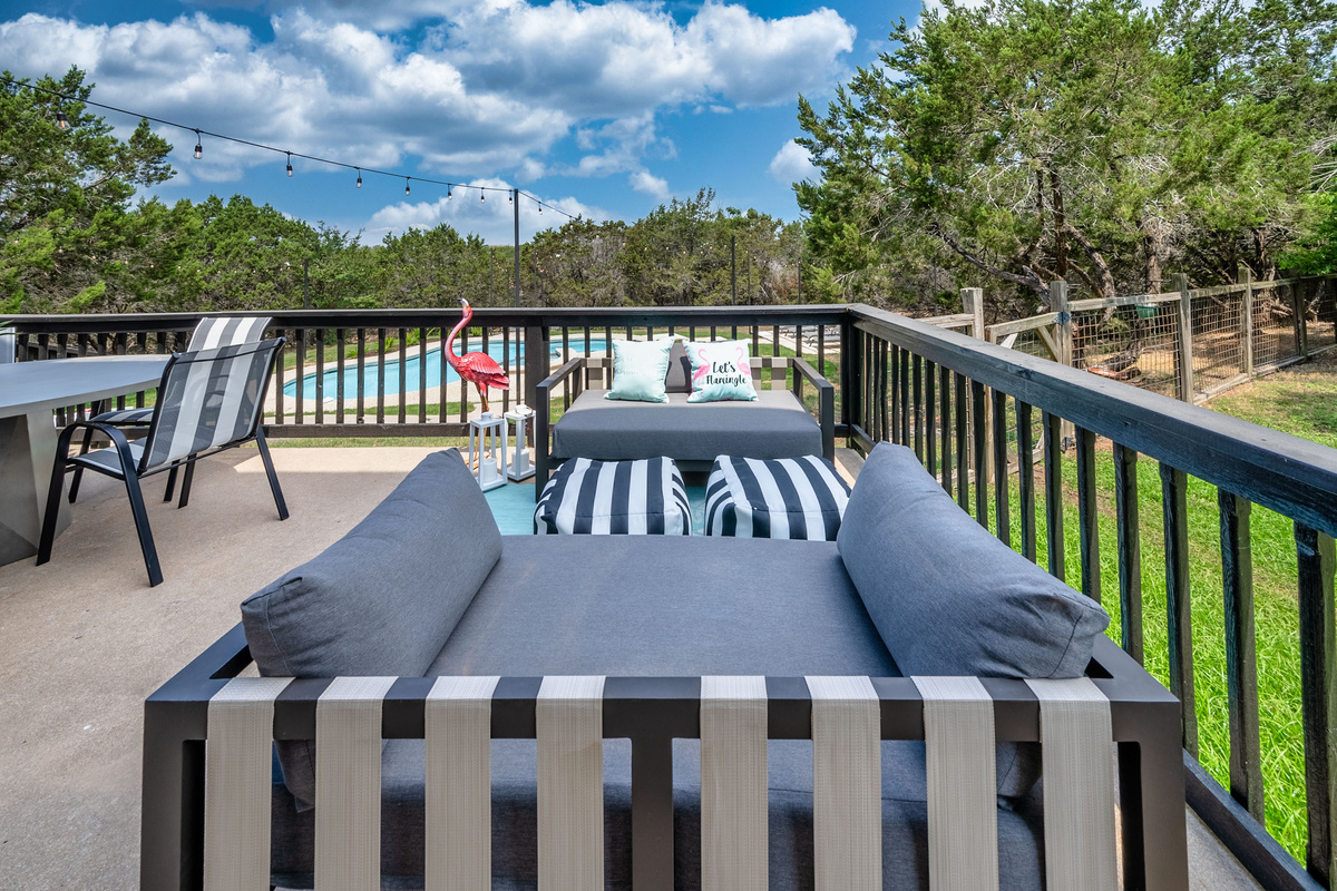 Panoramic pool and treeline views from the private balcony lounge.
