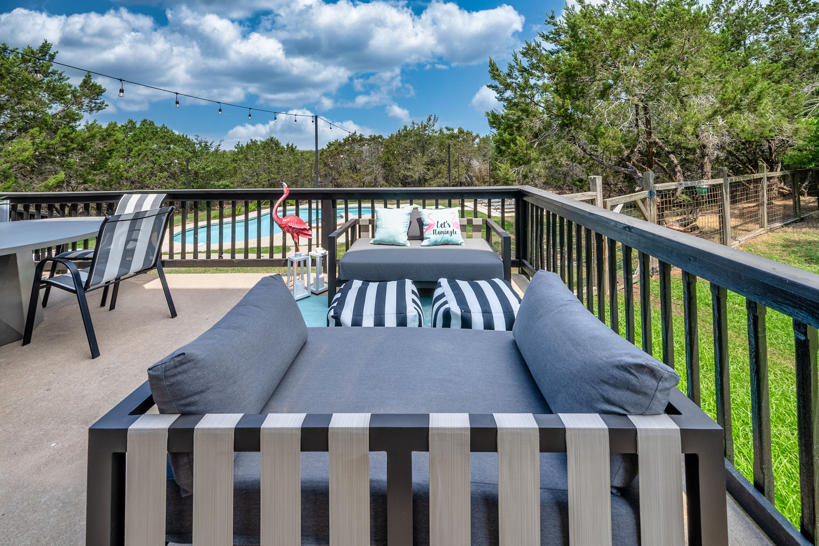 Panoramic pool and treeline views from the private balcony lounge.