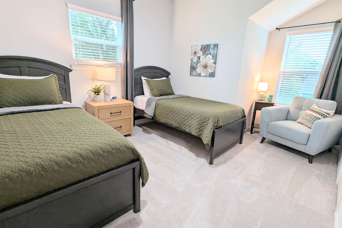 Twin beds for extra sleeping space and flexibility and a comfy reading nook are located in this upstairs bedroom. 