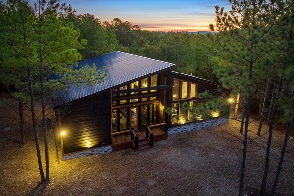 Enjoy peaceful seclusion in this beautifully designed woodland getaway with expansive windows and cozy lighting.
