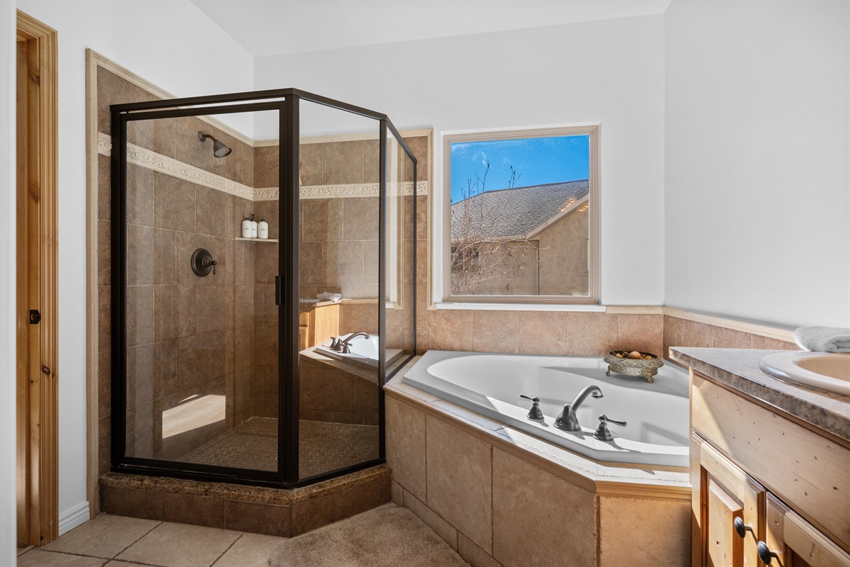 Experience the spacious shower enclosed with a sleek glass door.