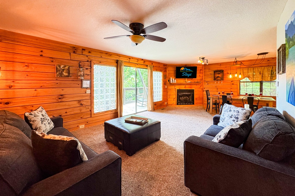 Main level living room featuring an open space, comfy seating, and a 55" Smart TV.