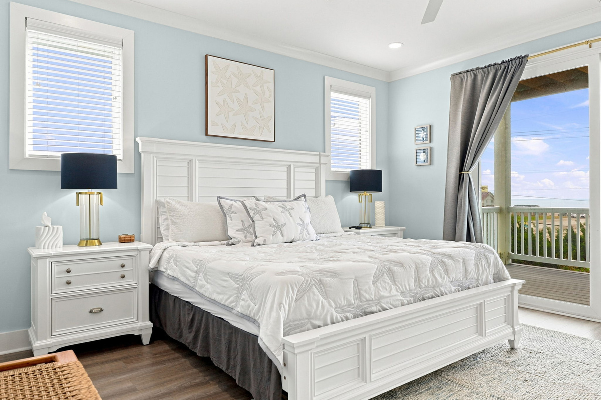 Wake up refreshed in this serene king master bedroom, featuring coastal touches, private balcony access, and a peaceful space to relax after a day at the beach