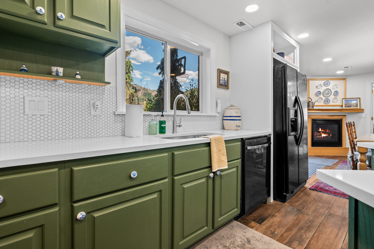 Natural light, generous counter space, and a seamless connection to the adjoining dining area make this fully equipped kitchen both stylish and practical.