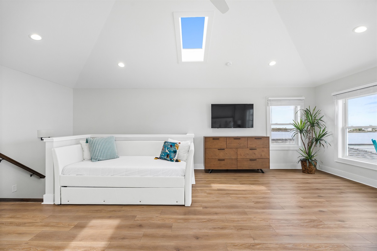 Relax in the expansive loft-style bedroom complete with TV, lounge area, and natural light throughout
