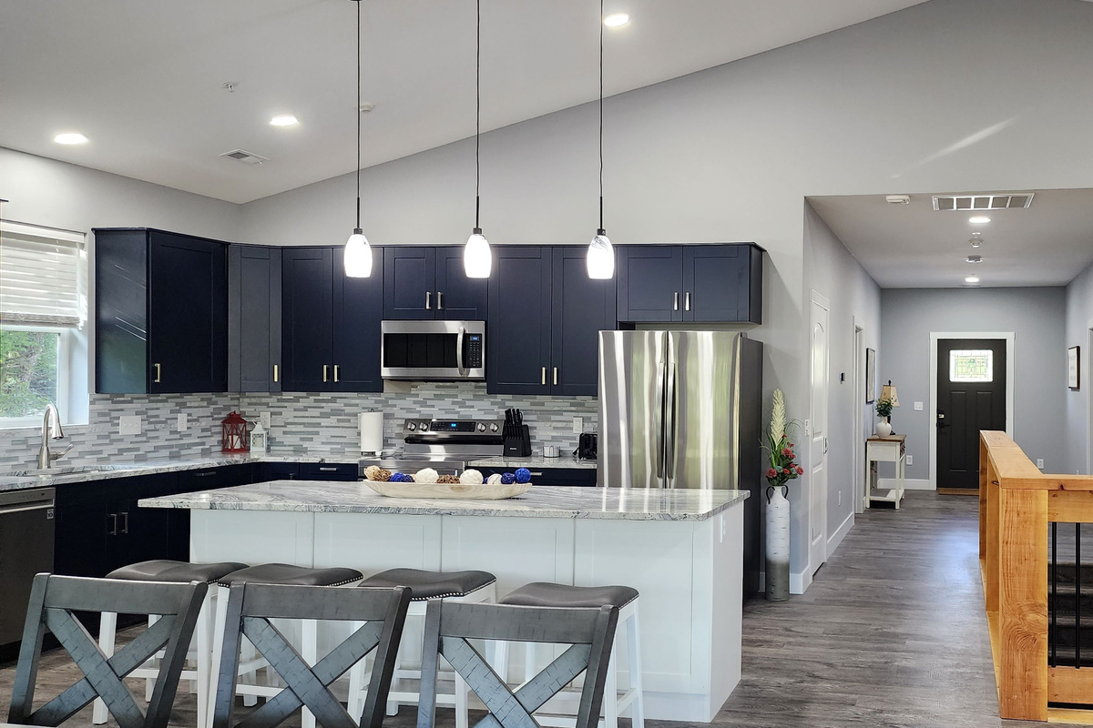 Modern, fully equipped kitchen with large island seating and open flow to entry.