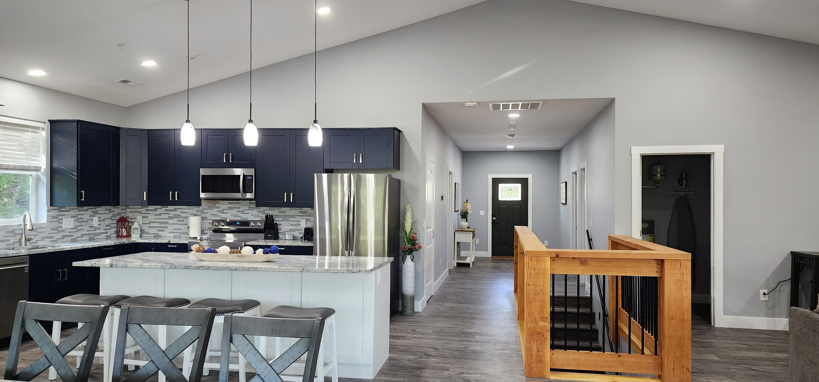 Modern, fully equipped kitchen with large island seating and open flow to entry.