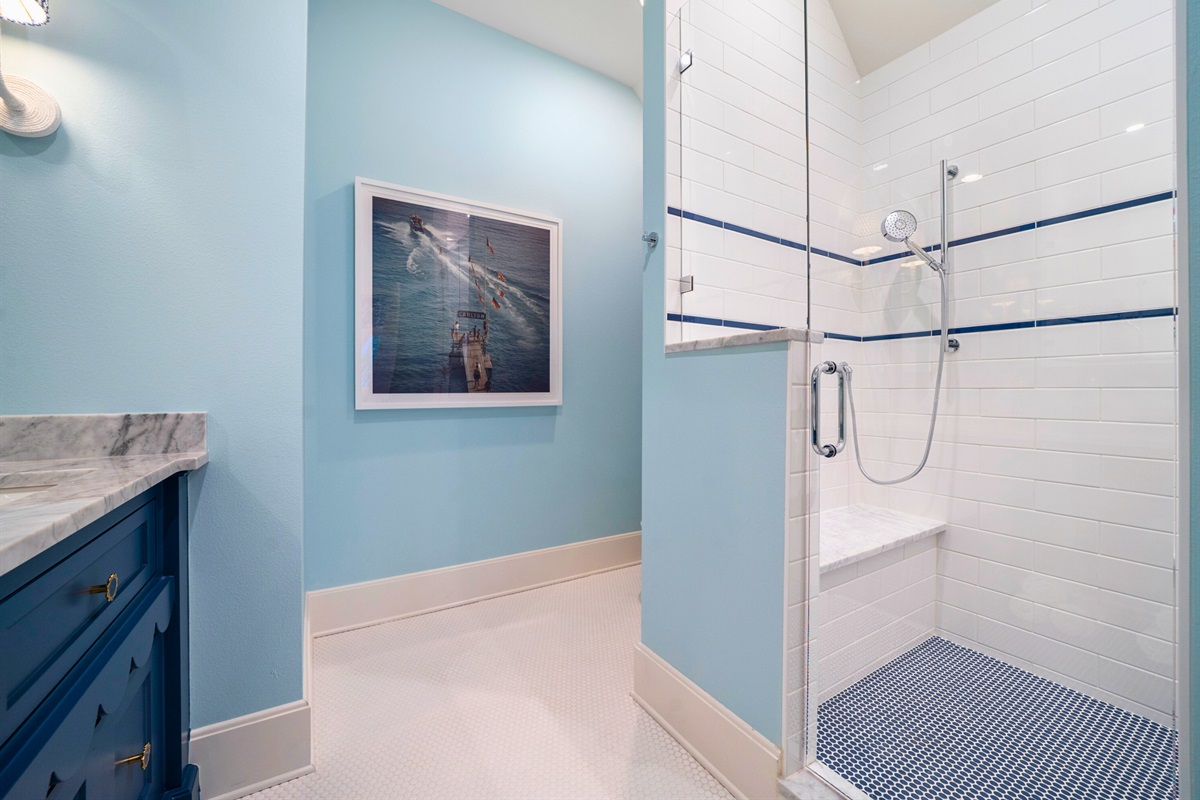 Accessible bathroom with open shower and modern finishes.