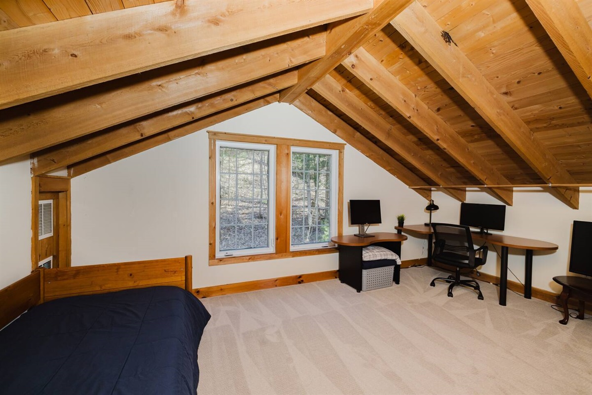 Loft with twin trundle bed dedicated work space, and TV. Please note there is a privacy screen separating the loft from the stairs leading down to the main level.