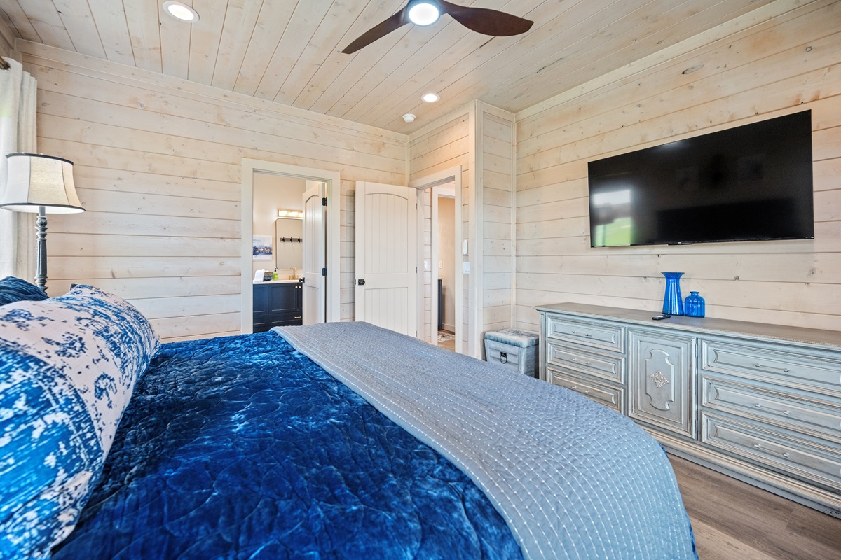 Bedroom 2 with king bed, dresser, and wall-mounted TV.