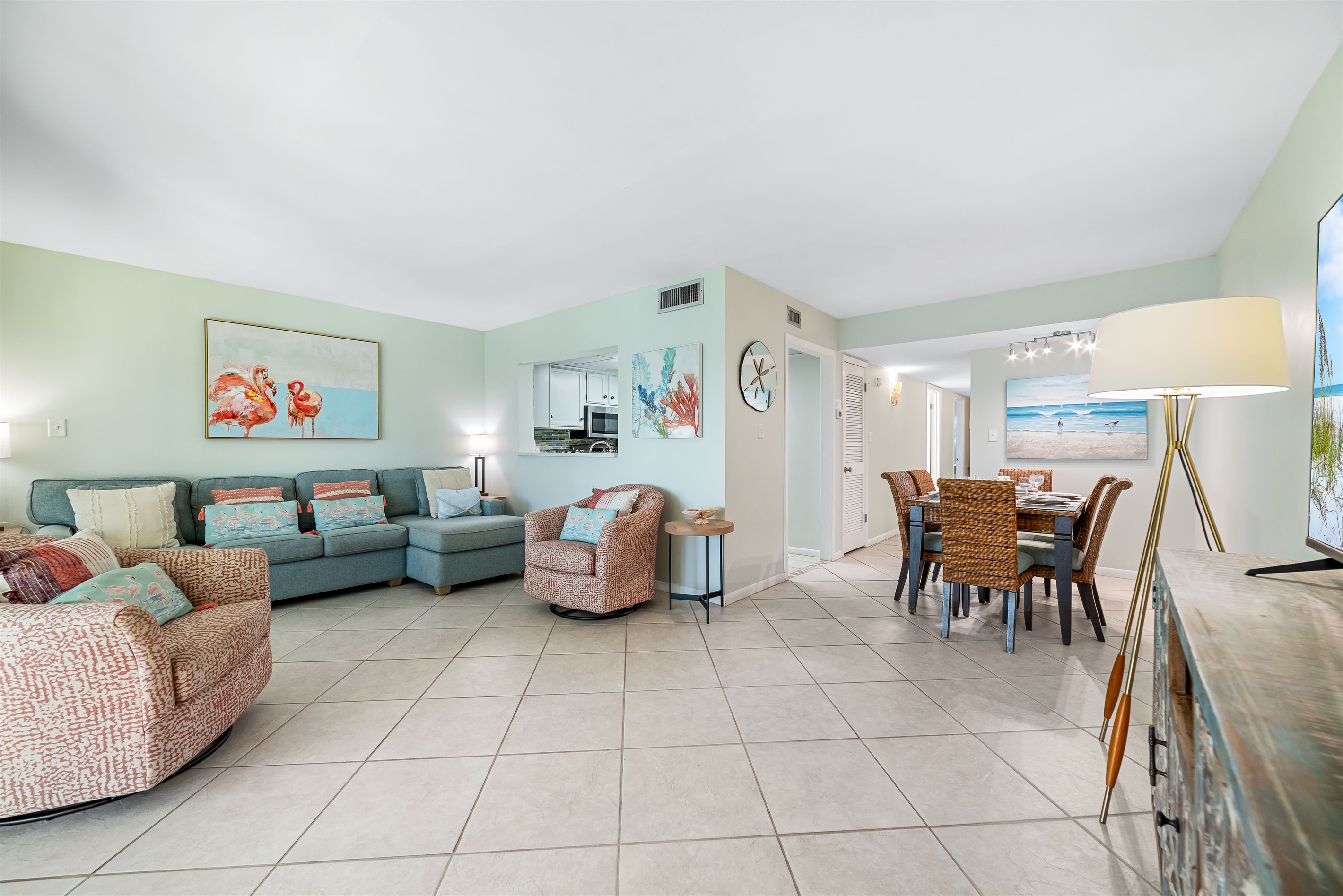 Comfortable and stylish living room featuring ample seating, a coastal-inspired palette, and expansive sliding doors leading to the oceanfront.