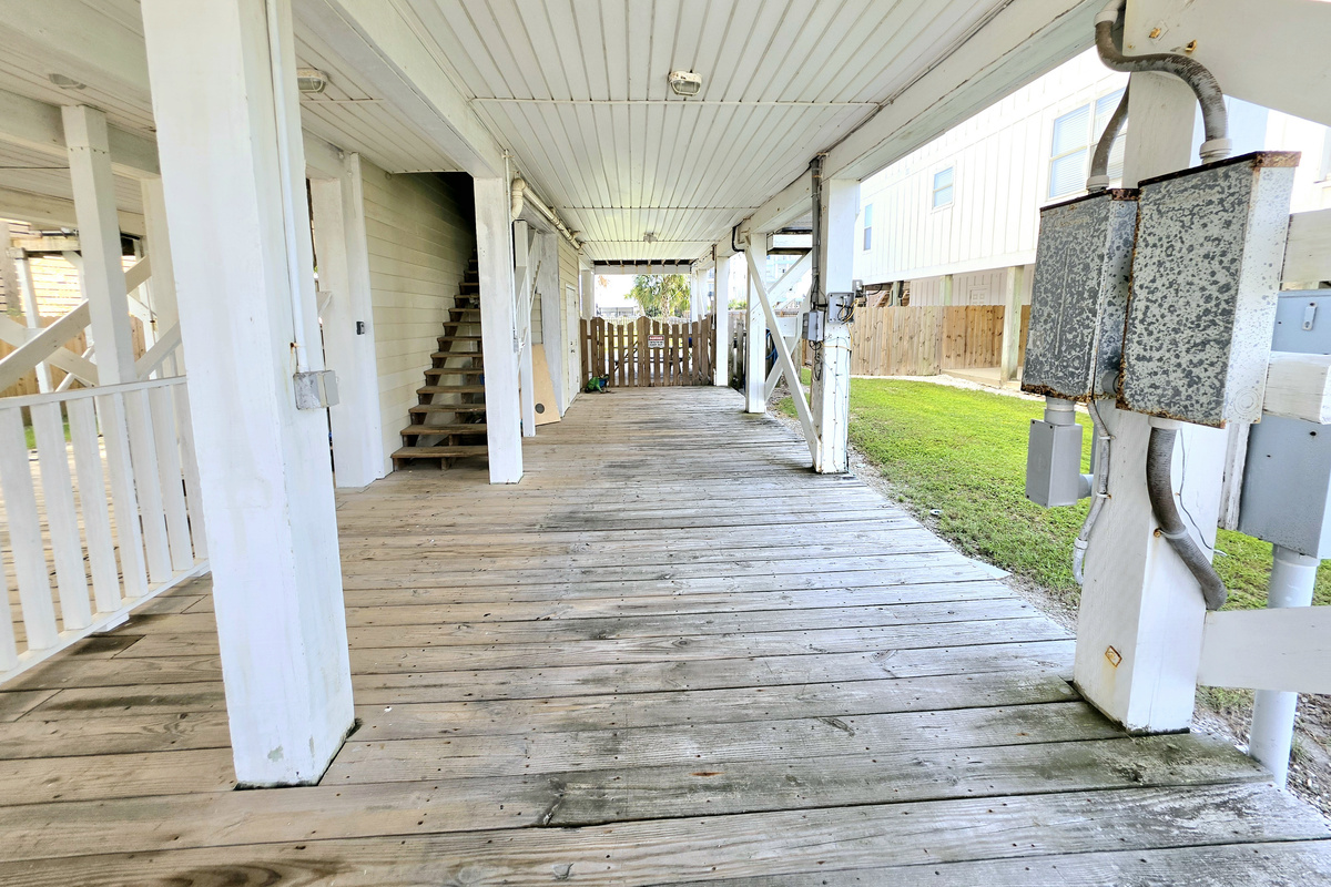 Covered ground-level deck with stairs up to the home