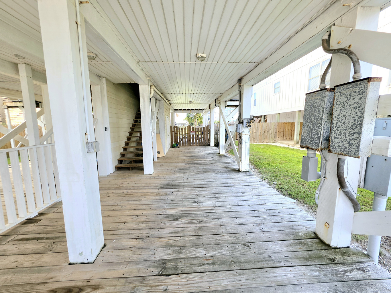 Covered ground-level deck with stairs up to the home