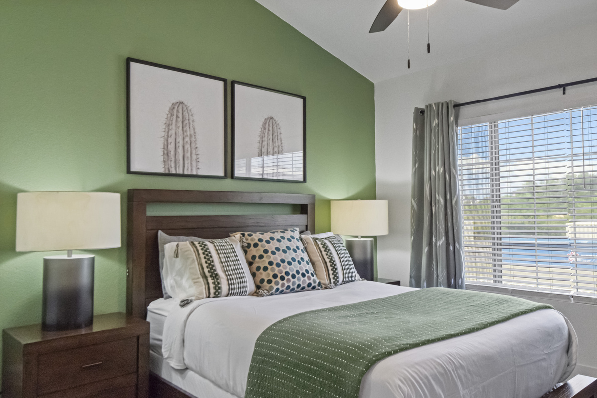 Relax in the inviting primary bedroom with a comfortable bed, stylish décor, bedside lamps, and natural light.