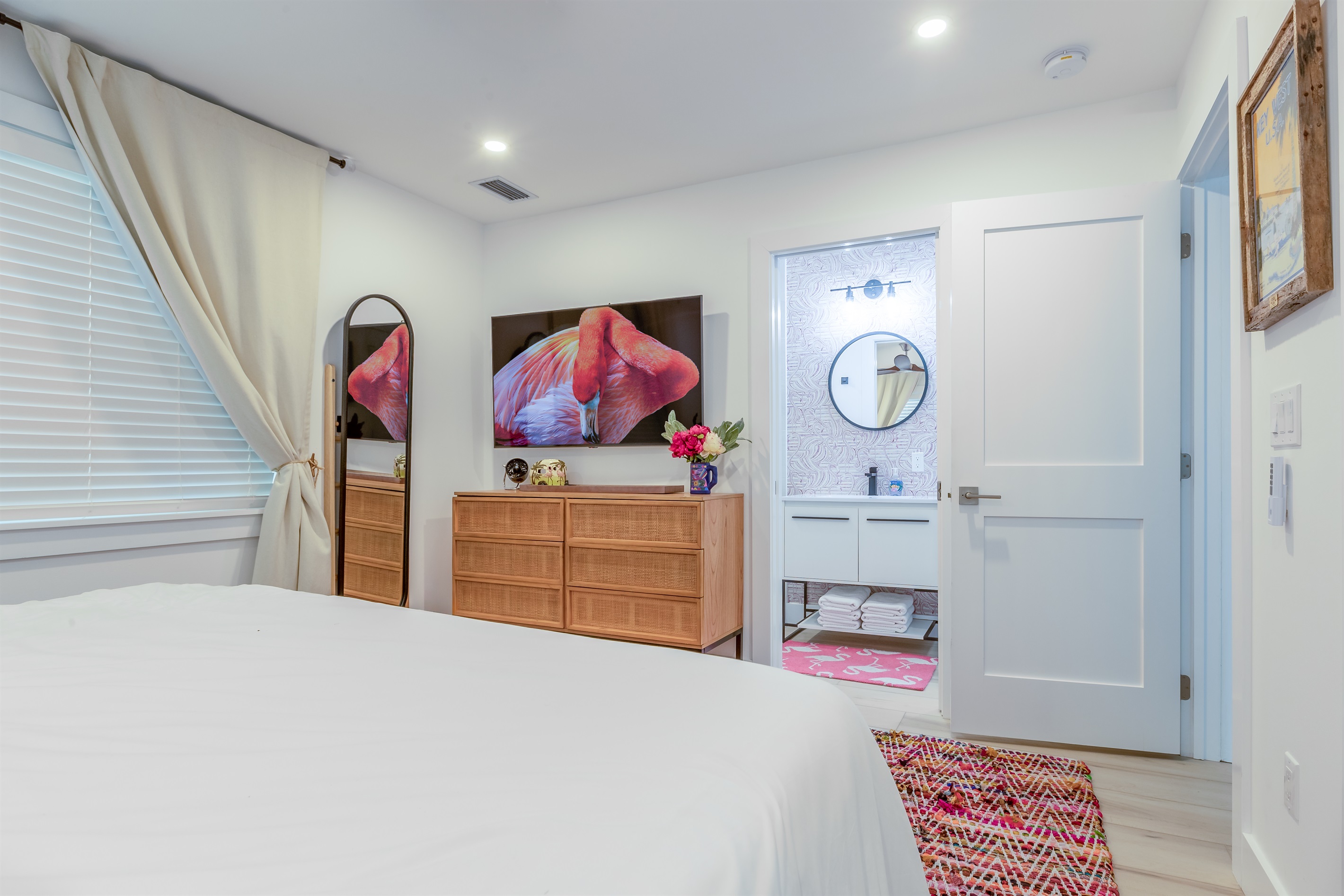 Bedroom Retreat: Bright room with stylish decor, soft linens, and a view of the inviting bath!