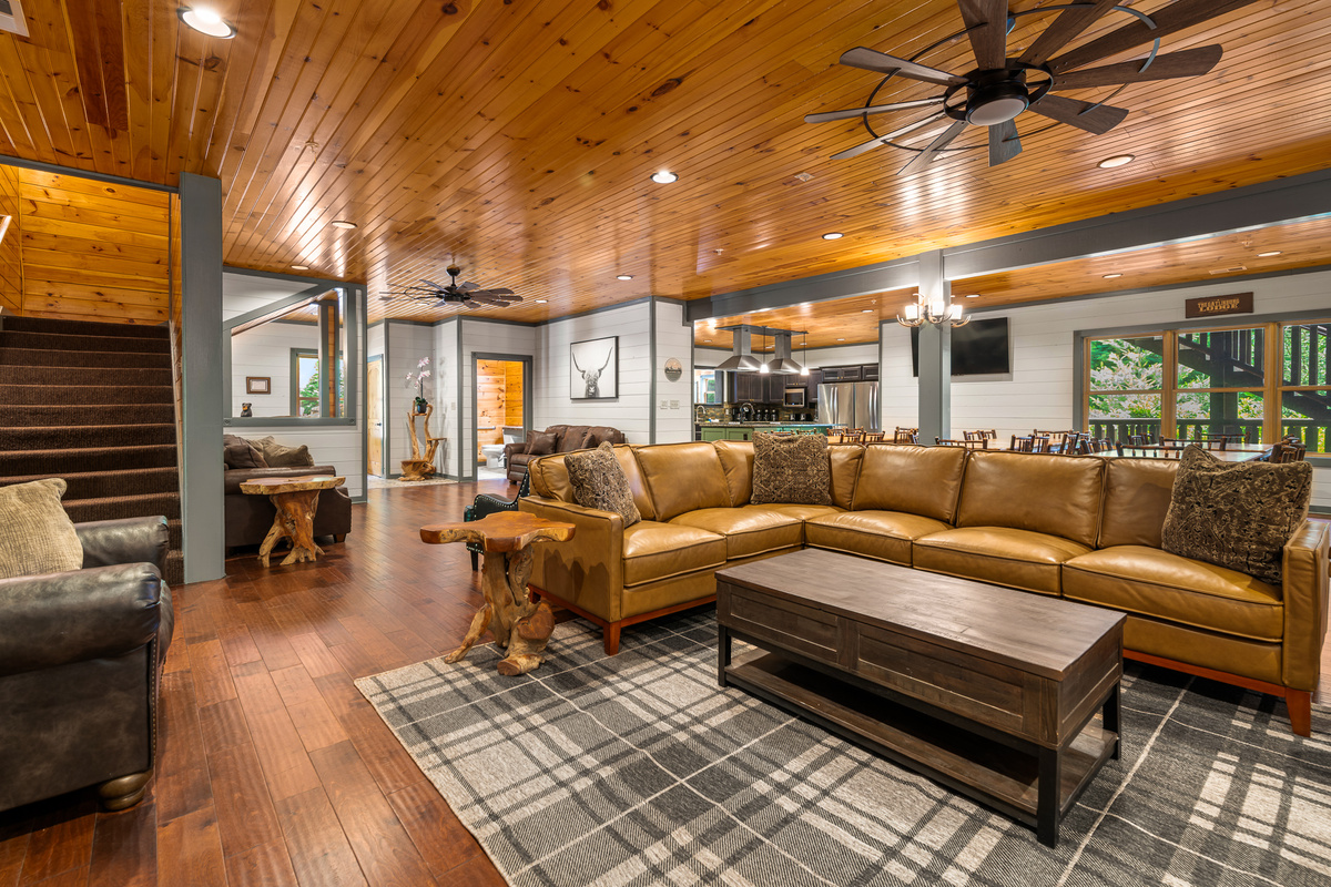 A 75" TV, roaring fireplace, and oversized Italian leather sectional anchor the main living room — with multiple separate hangout zones so the full group never feels crowded into one corner. Two pull-out beds.