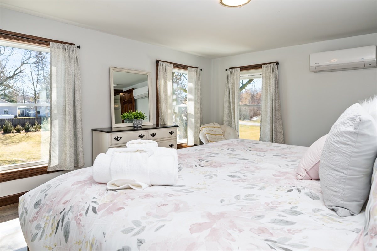 Bright, spacious bedroom with cozy seating and views of the scenic outdoors—perfect for morning coffee or unwinding after wine tasting.
