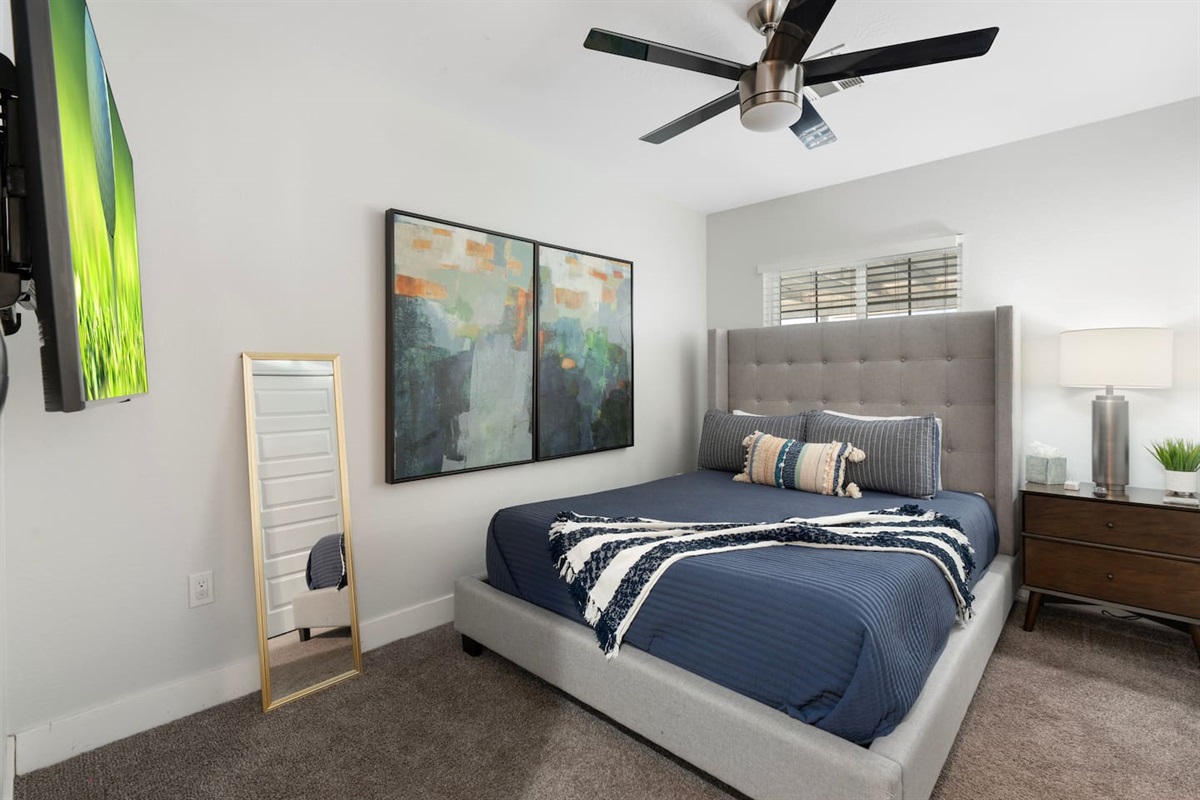 Spacious bedroom with a sleek mirror, enhancing the room's sense of openness and style.