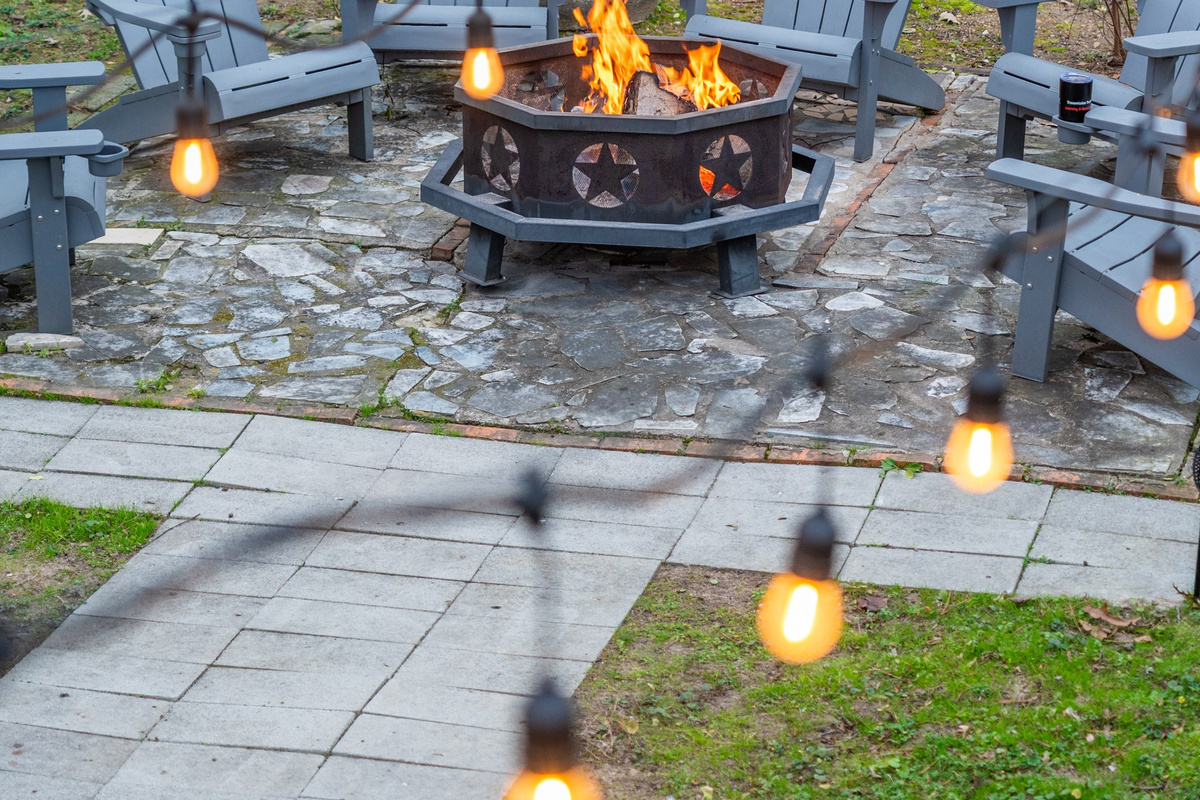 Pull an Adirondack chair up to the fire as the string lights come on — the backyard turns into the best room in the house.
