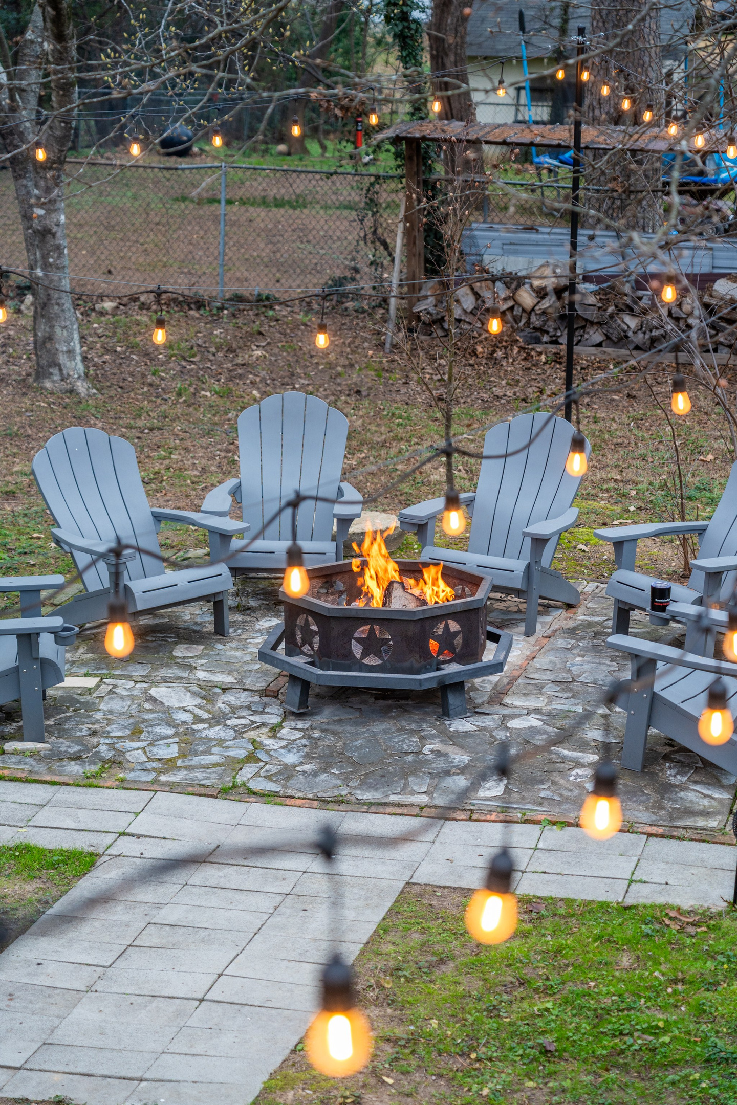 Pull an Adirondack chair up to the fire as the string lights come on — the backyard turns into the best room in the house.