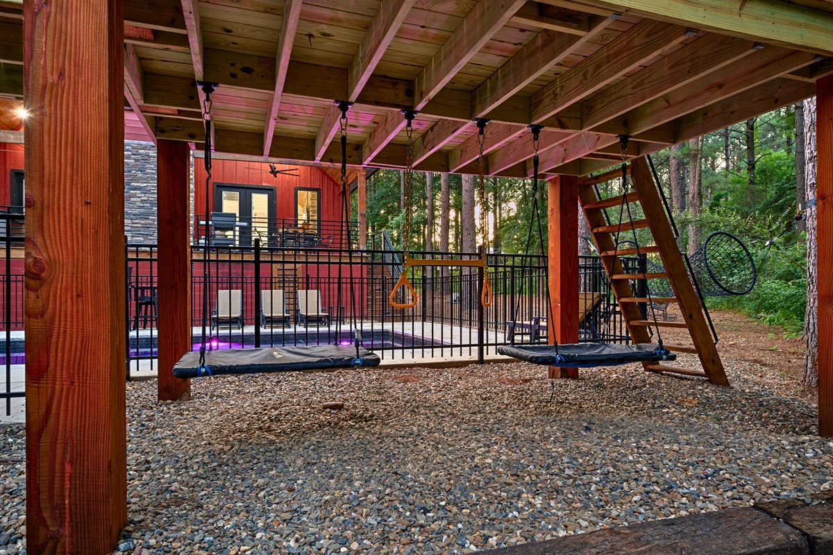 Beneath the deck, discover a shaded swing set and play area—perfect for letting kids unwind while staying close to the action.
