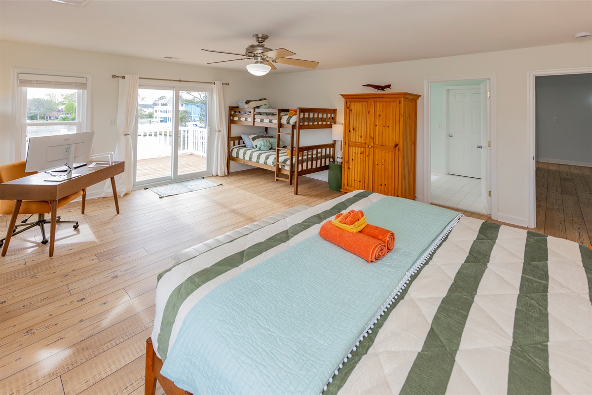 The primary suite has a King sized bed, a set of Twin bunks, and a desk for those who work remotely, in addition to a private balcony and a master bathroom
