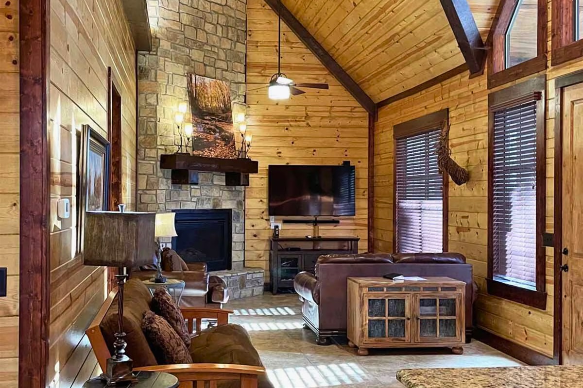 Rustic charm meets comfort inside, with stone fireplace, warm wood, and space to gather after a day exploring.